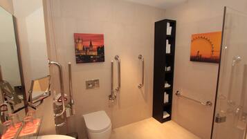 A modern bathroom with a glass shower enclosure, a white toilet, and a glass sink.