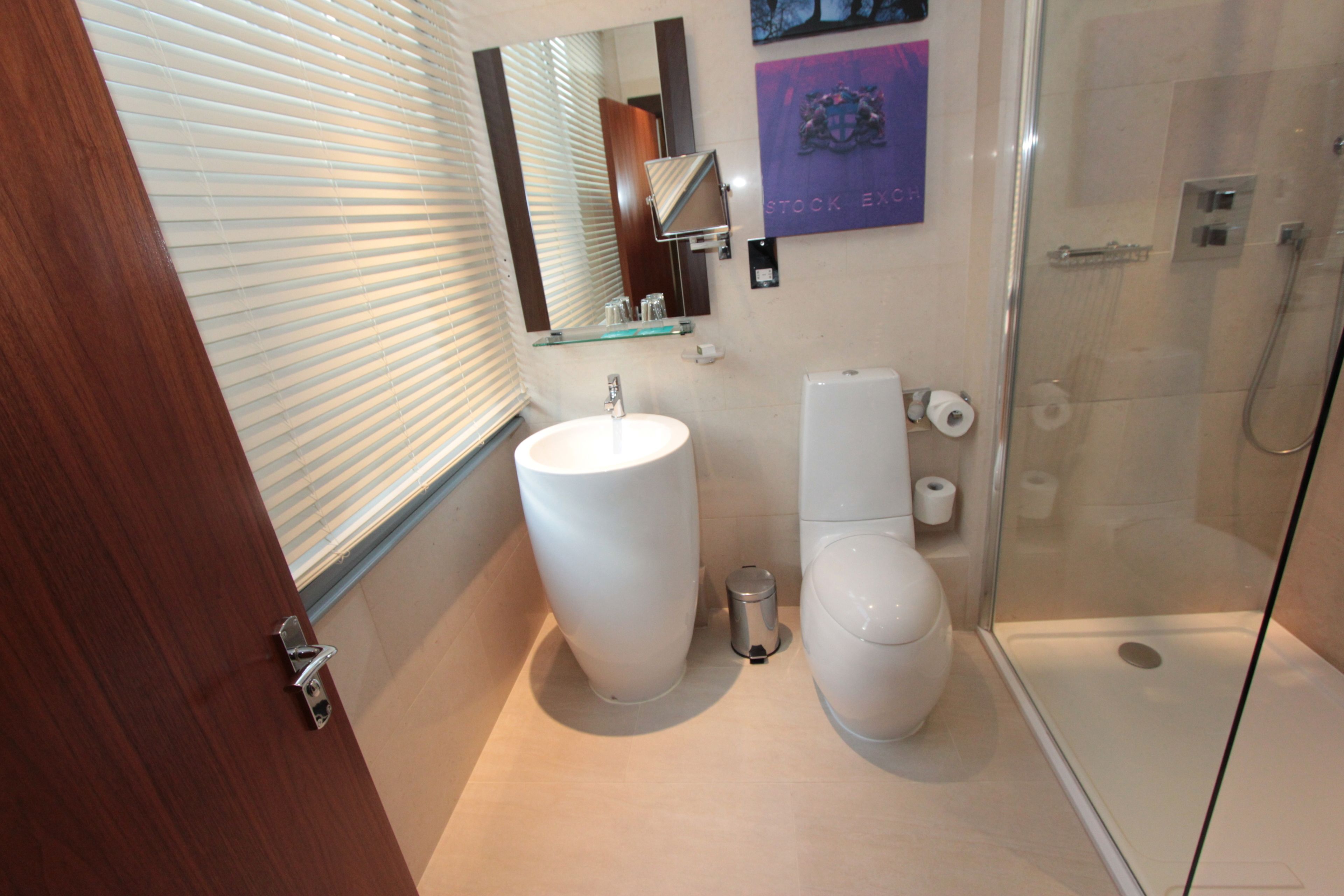 A bathroom with a sink, toilet, and glass shower enclosure.