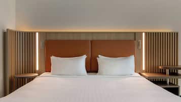 Ein Doppelbett mit Holz-Kopfteil und zwei Nachttischen.