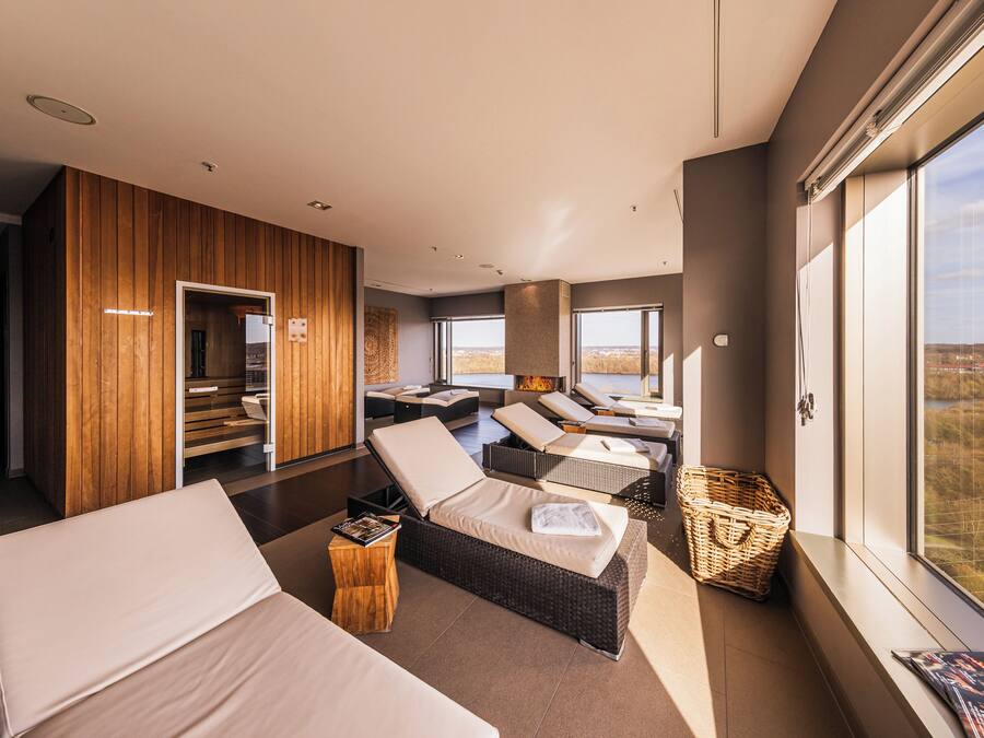 A modern room with a large window, a fireplace, and a seating area with a view.