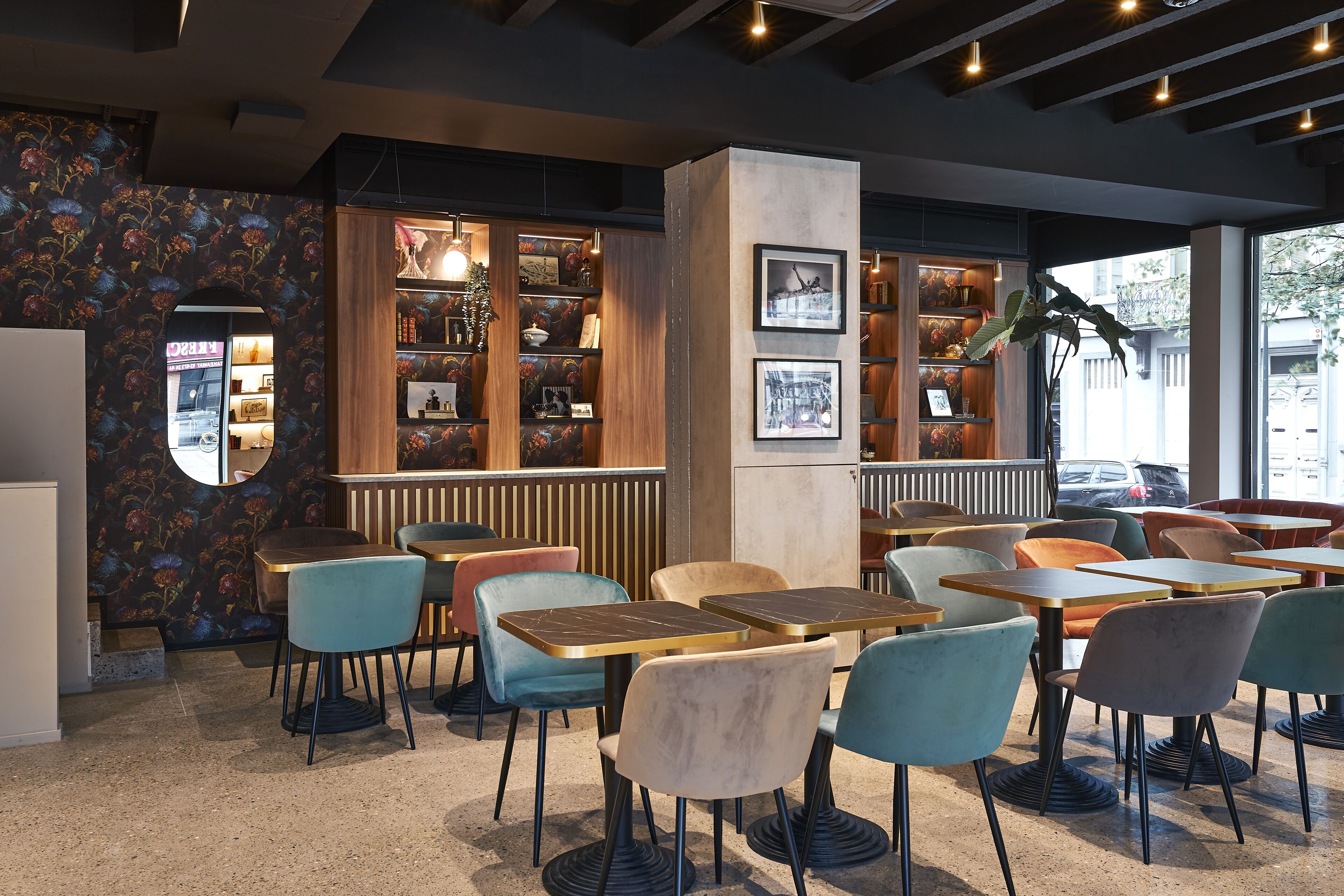 A cafe with wooden shelves, tables, and chairs.