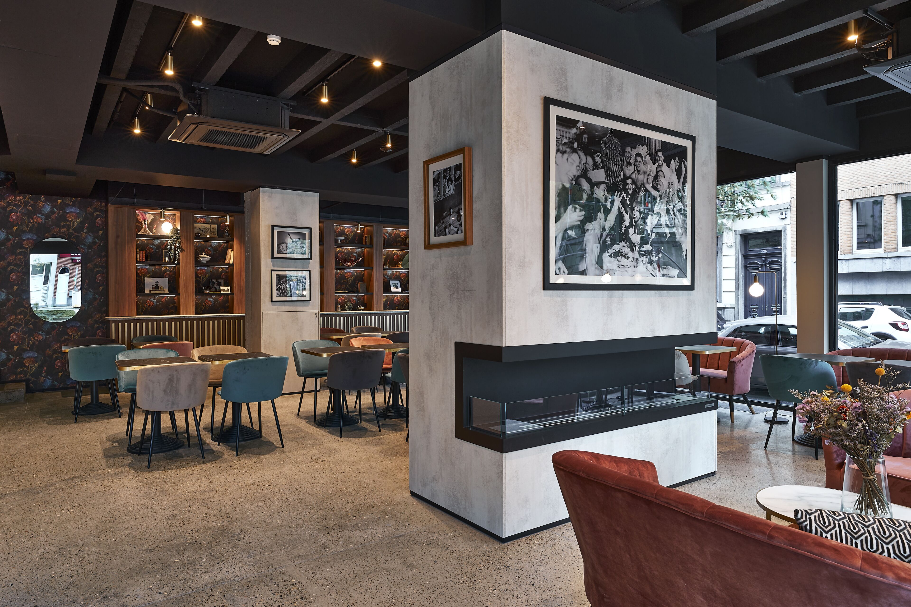 Un interior moderno con chimenea, zona de estar y una pared con fotografías enmarcadas.