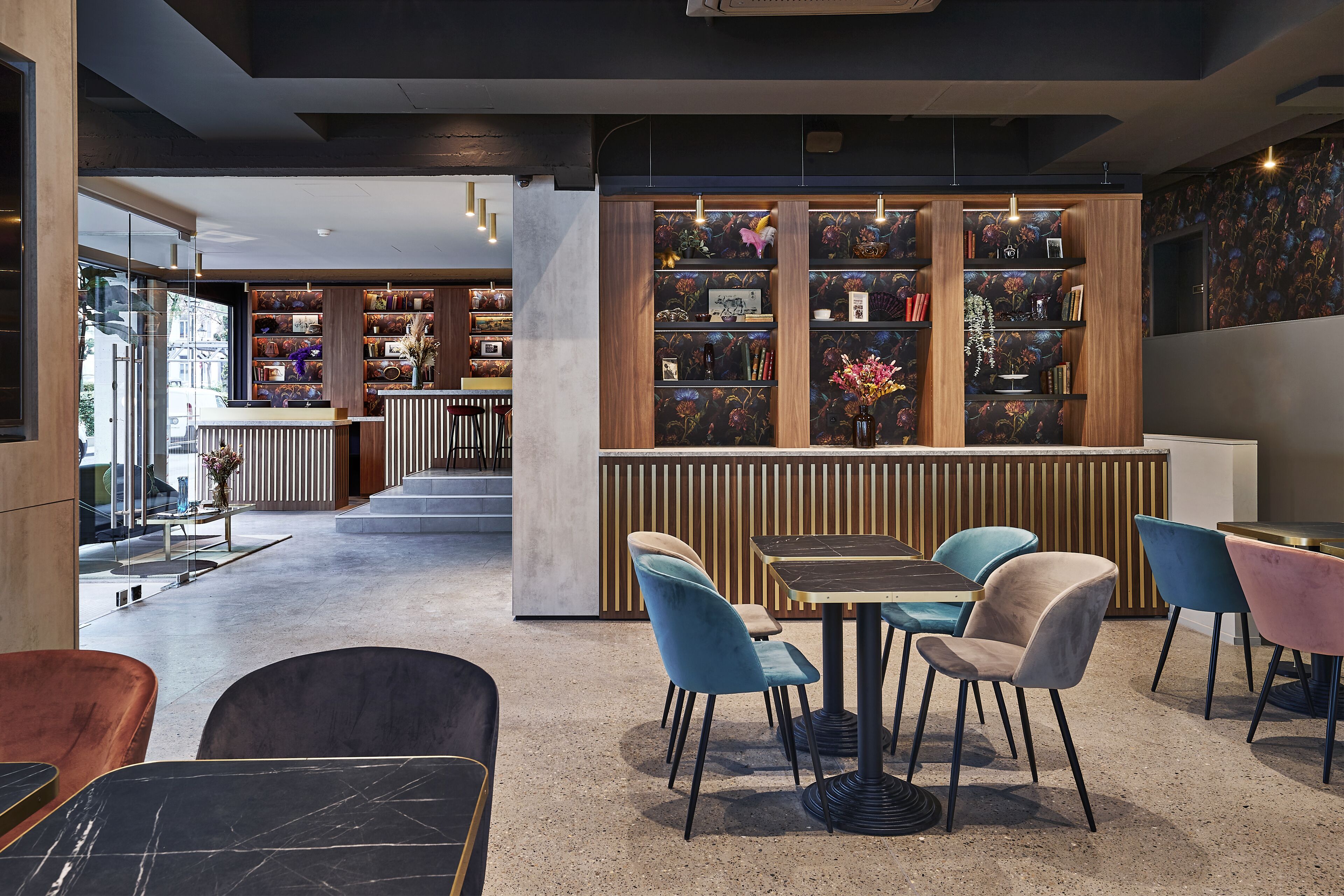 Een modern interieur met een centrale zithoek, een houten boekenkast en uitzicht op de straat.