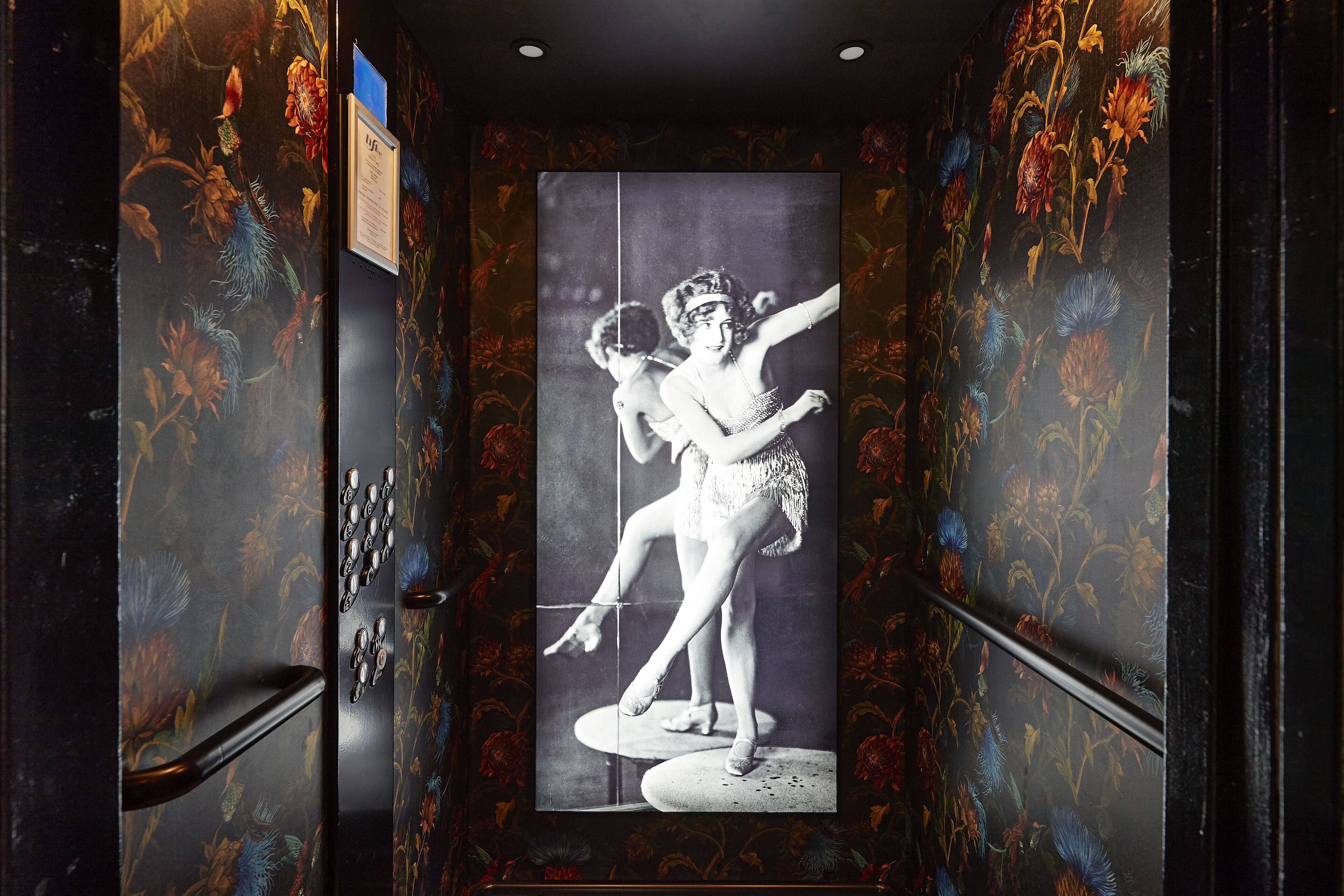 Een gang met een groot zwart-witfoto van dansers aan de wand.