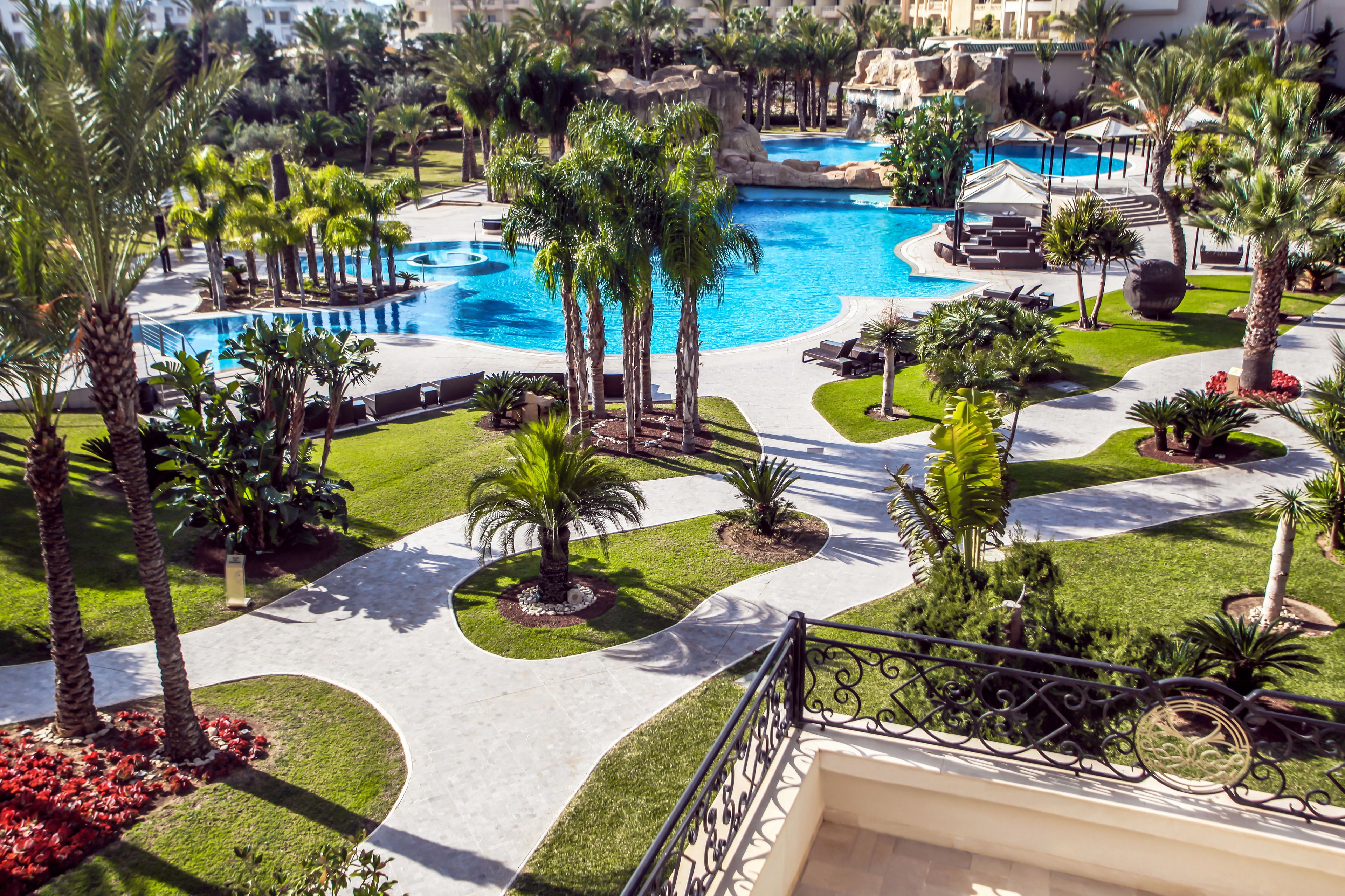 Una piscina cubierta, una piscina al aire libre, sombrillas