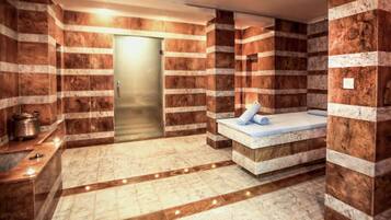 A spa room with a marble floor, a massage table, and a wall with a striped pattern.