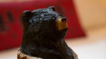 A wooden sculpture of a bear's head on a wooden post.