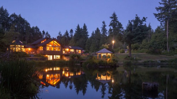 A lakeside lodge with multiple wooden cabins, a gazebo, and a reflection in the water. - A Hidden Haven & Water Garden Cottages (Port Angeles)
