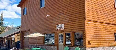 A wooden lodge with a sign reading "ONE EAGLE LODGE OFFICE".