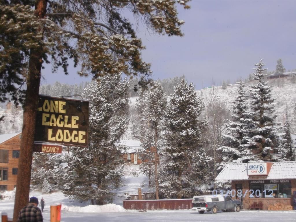 Un chalet enneigé, avec une pancarte indiquant qu’il y a des chambres disponibles.