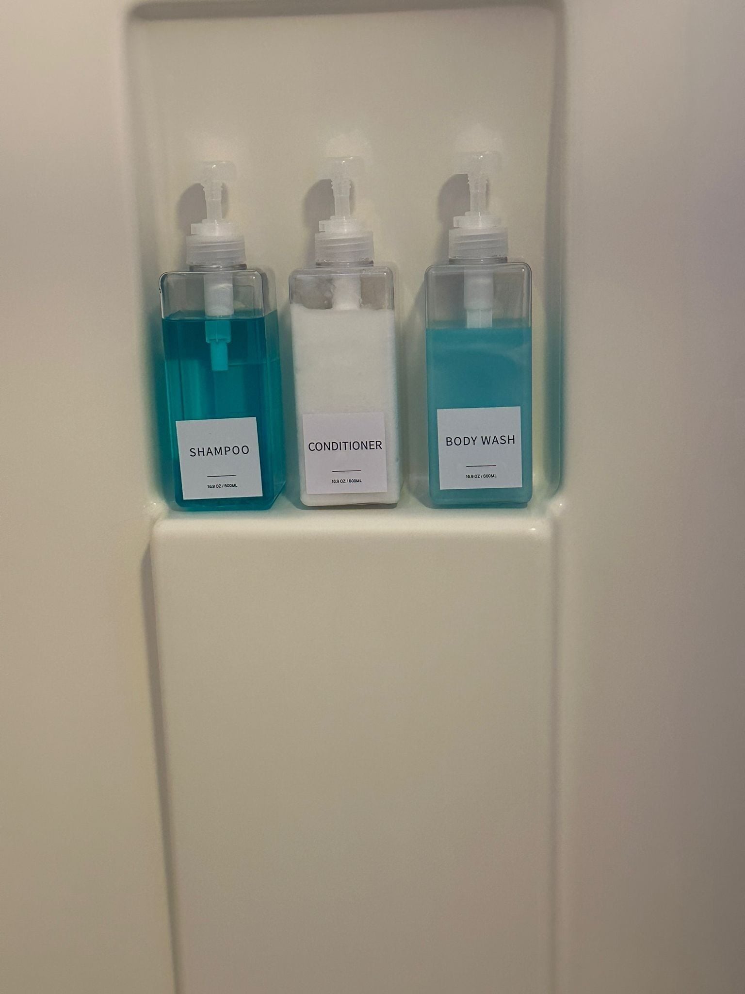 Kolme pulloa henkilökohtaisen hygienian tuotteita lokerossa.