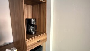 A compact kitchenette with a microwave, coffee maker, and a small cabinet. - Lone Eagle Lodge (Grand Lake)