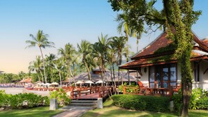 A resort with a pool, palm trees, and a covered seating area. - Khaolak Laguna Resort (Takua Pa)