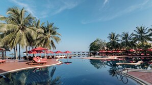 A pool area with lounge chairs and umbrellas, surrounded by palm trees. - Khaolak Laguna Resort (Takua Pa)