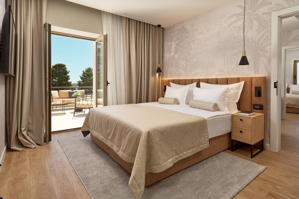 Un hotel moderno con una cama grande, una mesita de noche y vistas al exterior.