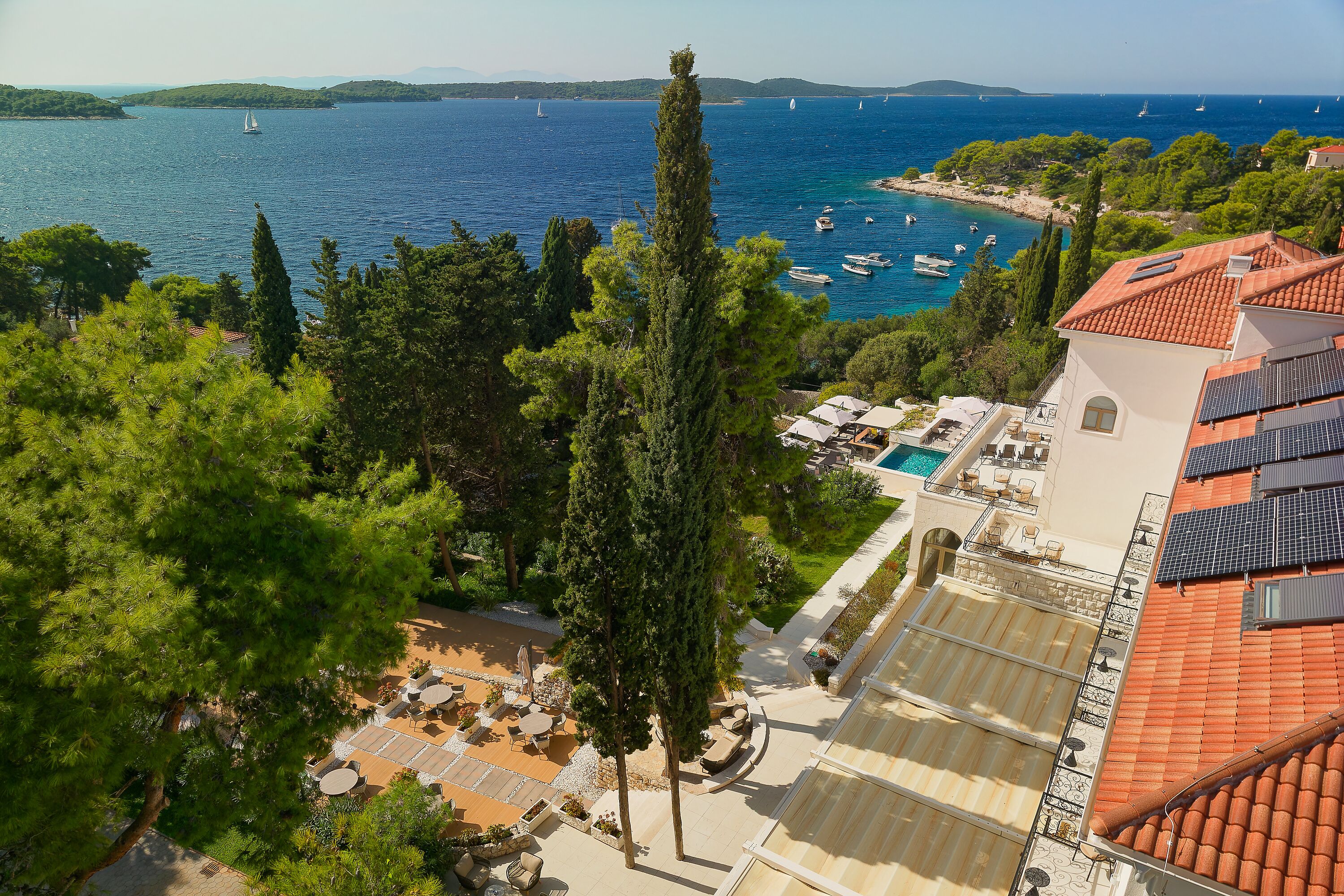A coastal hotel with a rooftop terrace, a swimming pool, and views of the sea.
