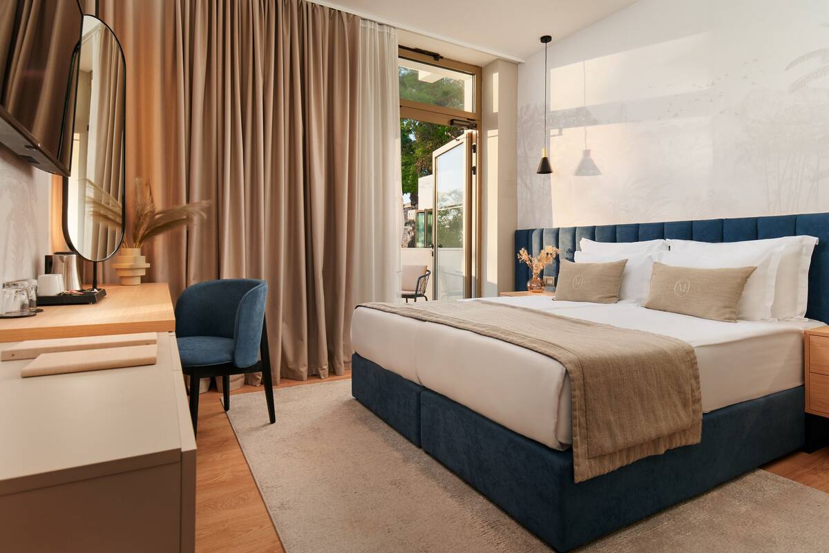 Un dormitorio moderno con una cama grande, un escritorio y una silla.