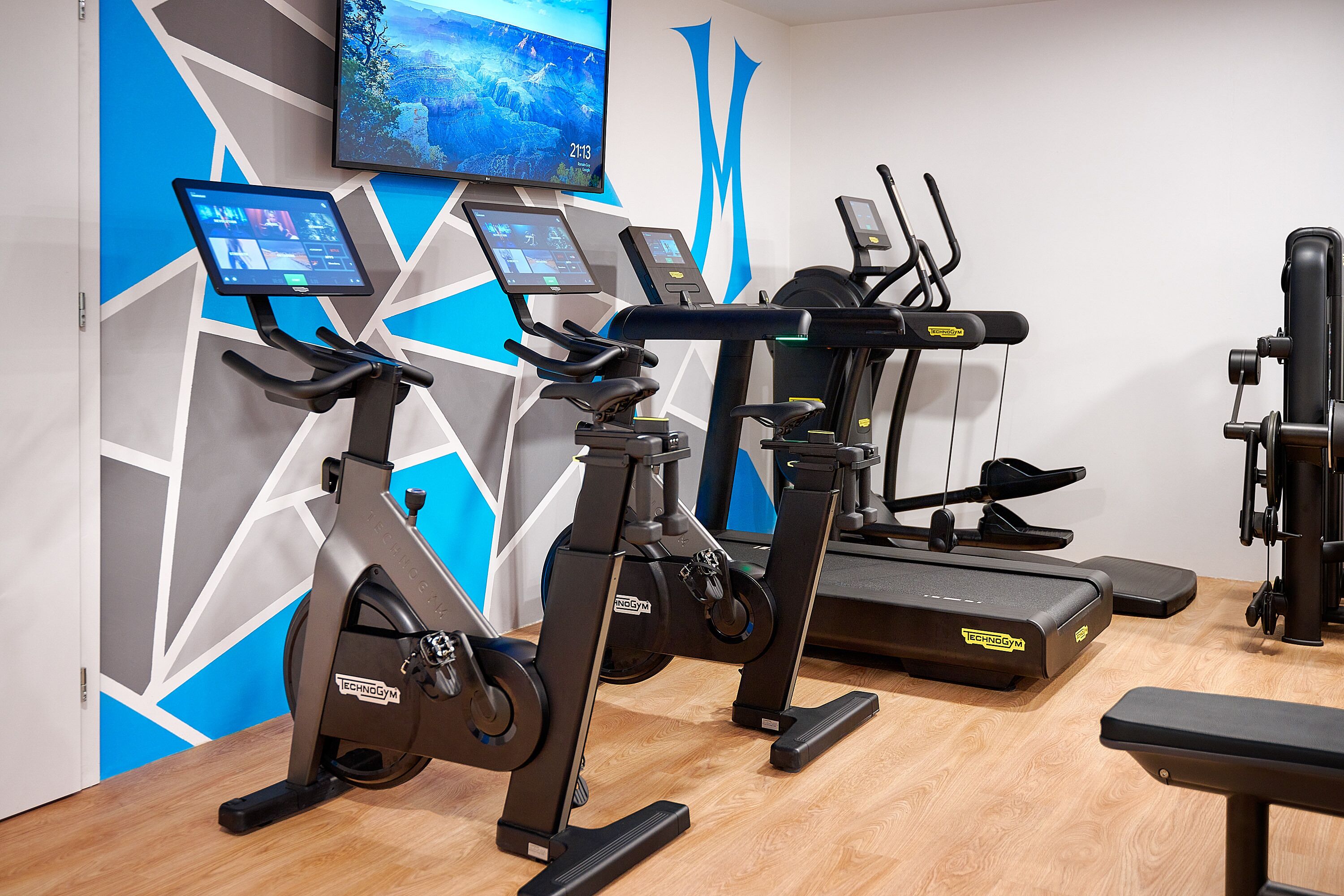 A gym with stationary bikes, treadmills, and a weight machine.