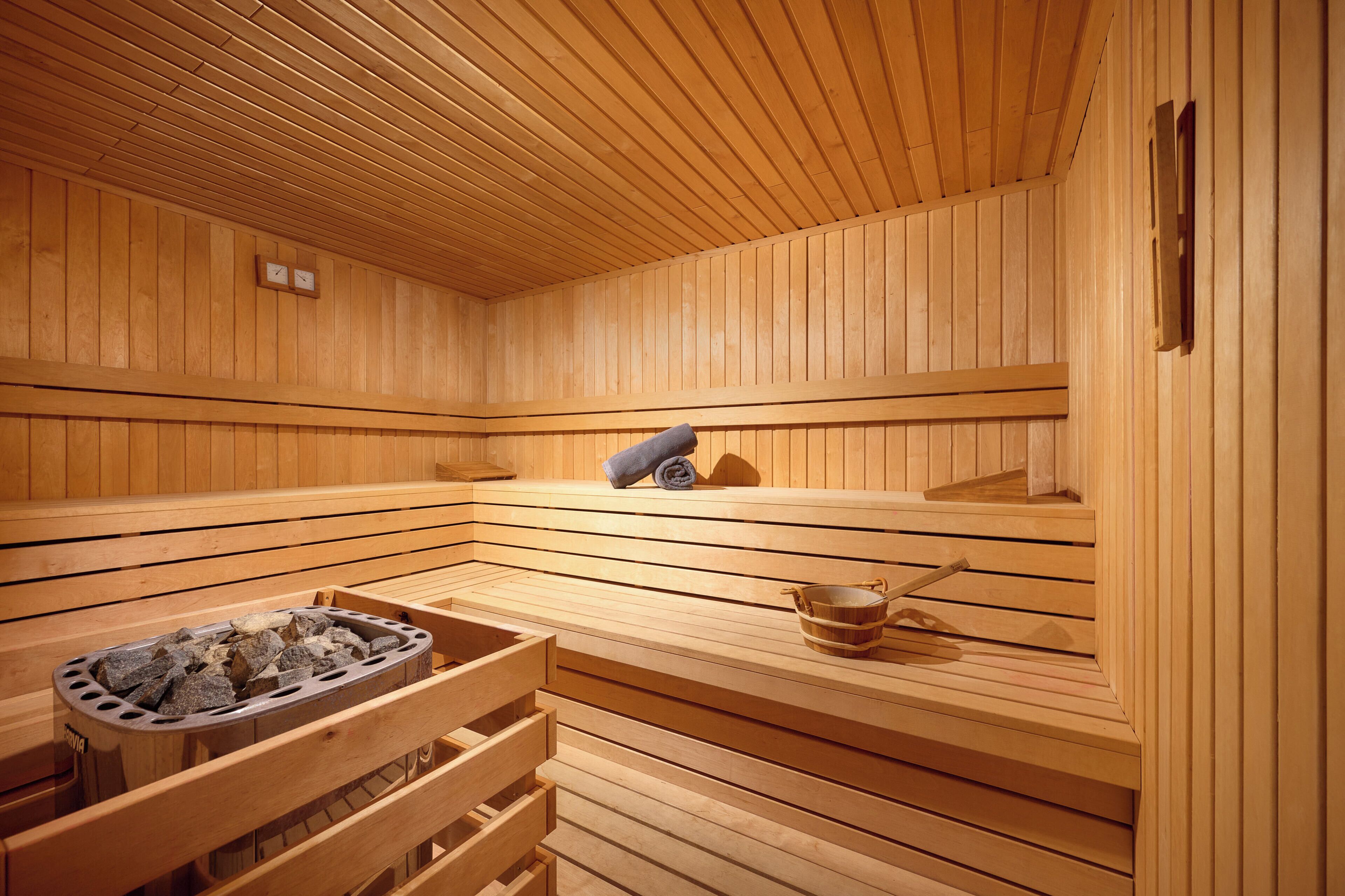 Una sauna con panche di legno, uno scaldasalviette e un catino.