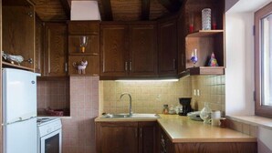 A kitchen with wooden cabinets, a white stove, a sink, and a window.