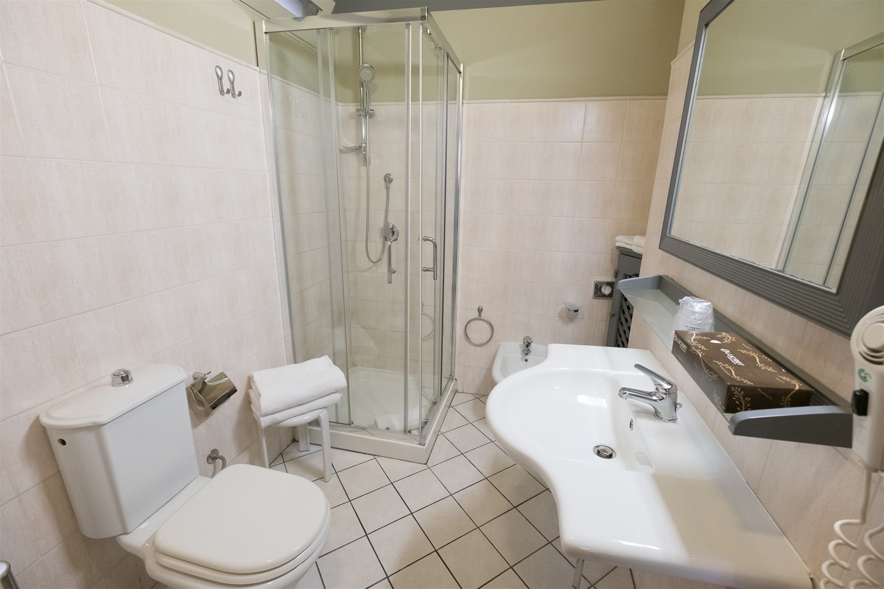 A bathroom with a toilet, sink, and shower.