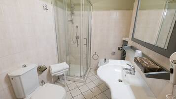 A bathroom with a toilet, sink, and shower.