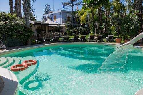 Una piscina al aire libre, tumbonas