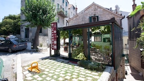 A stone building with a sign for "Villa Stina" and a covered outdoor seating area. - Authentic Luxury Rooms (Split)