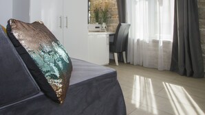 A modern room with a sofa, a decorative pillow, a desk, and a chair. - Authentic Luxury Rooms (Split)