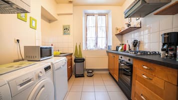 Eine kleine Küche mit Waschmaschine, Mikrowelle und Backofen.