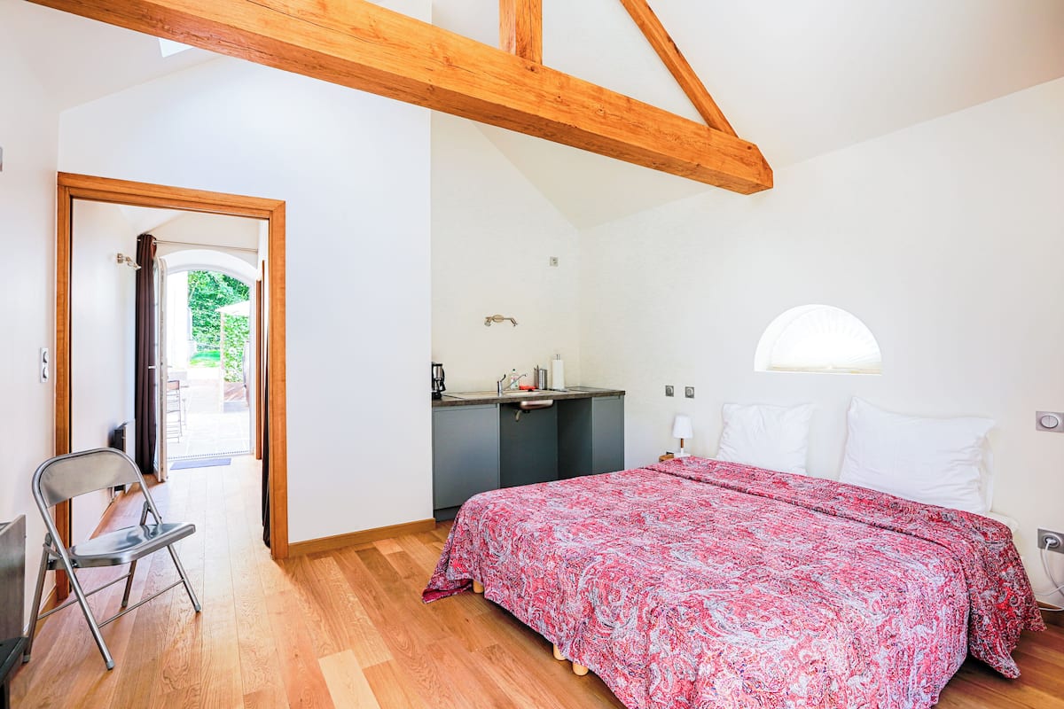 Un dormitorio con una cama, un escritorio y una silla.