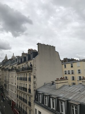 A row of historic buildings with varied architectural styles, including a prominent building with a large, flat roof and another with a rounded dome. - LUXELTHE Hôtel (Paris)
