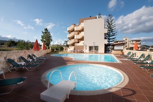 Una piscina al aire libre de temporada, sombrillas