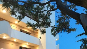 Um edifício moderno com vários andares, área de estar ao ar livre e entrada bem iluminada.
