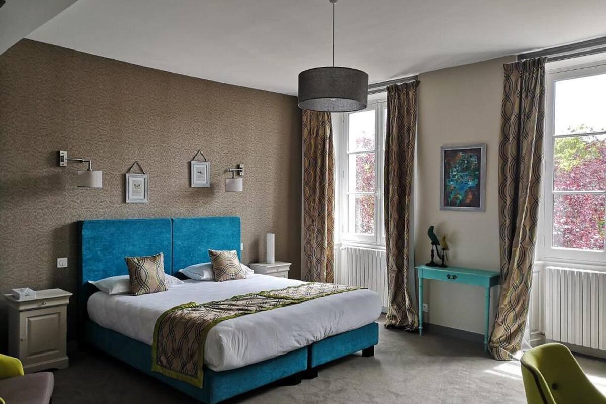 Une chambre à coucher avec un grand lit, des tables de chevet, un bureau et une chaise.