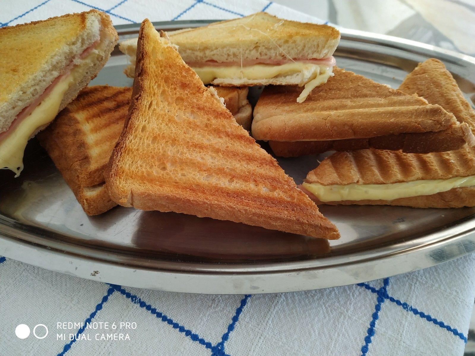 Une assiette de sandwichs grillés dont on peut voir la garniture.