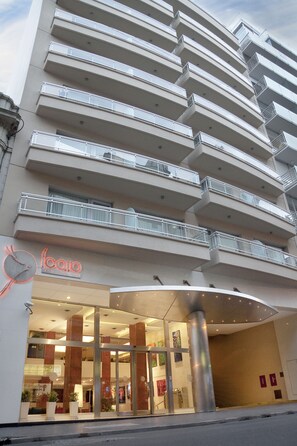 Un edificio moderno con varios balcones y una entrada de cristal.