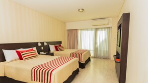 A hotel room with two beds, a TV, and an air conditioning unit. - Icaro Suites (Buenos Aires)