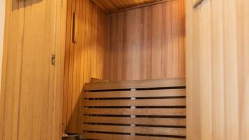 A wooden sauna with a slatted bench and a small window.