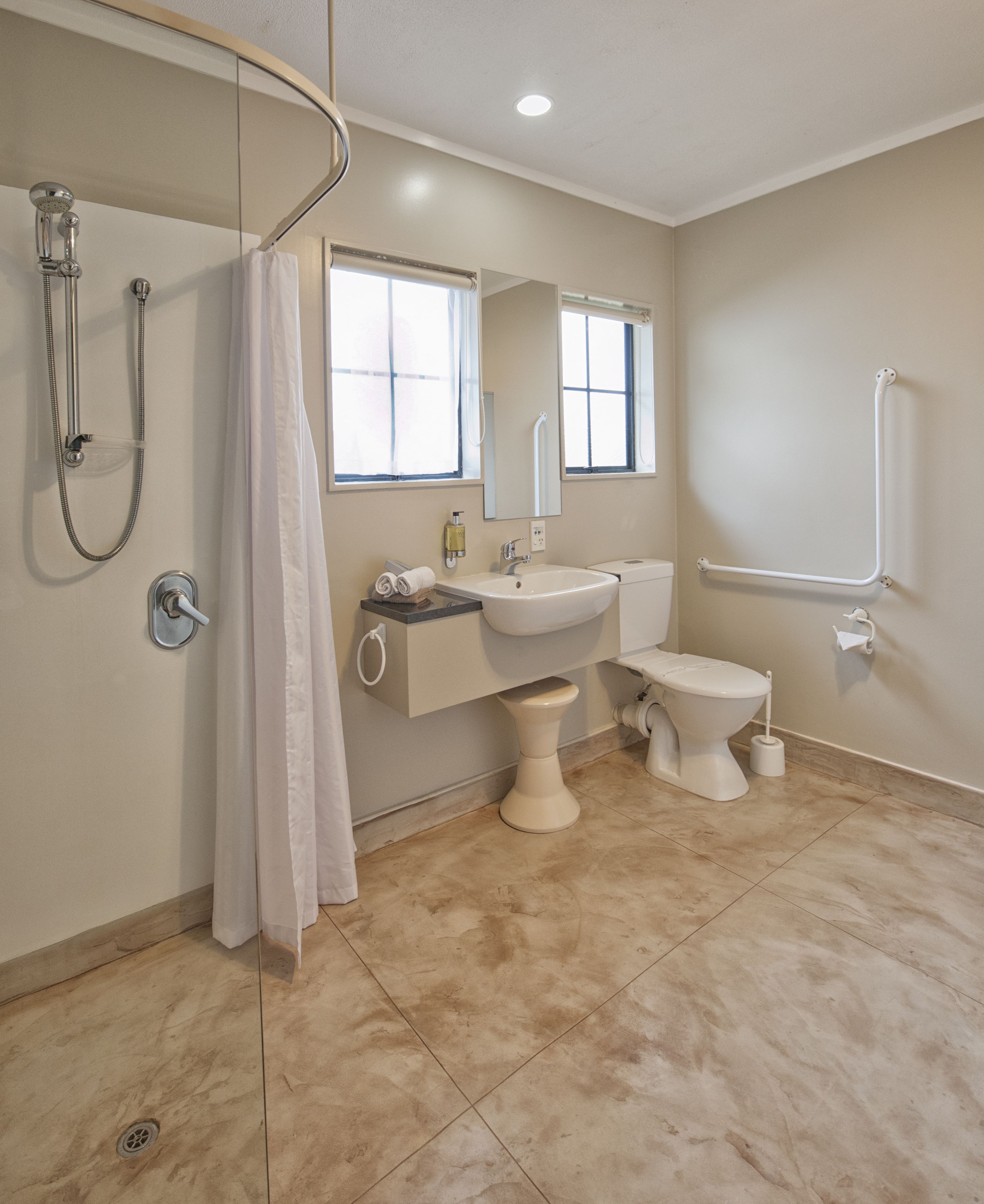 A modern bathroom with a shower, toilet, and sink.