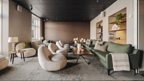 Un salon moderne comprenant un canapé, des fauteuils, une table basse et une bibliothèque.