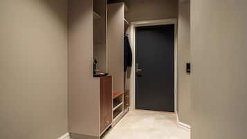 Un pasillo estrecho con un armario empotrado, una puerta y un interruptor de luz en la pared.