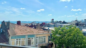 A residential area with tiled roofs, a view of the sea, and a clear sky. - Magnificent Hotel (Istanbul)