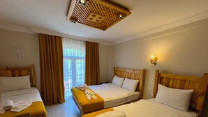 A hotel room with two beds, a wooden headboard, a wooden ceiling with a light fixture, and a window with curtains. - Magnificent Hotel (Istanbul)