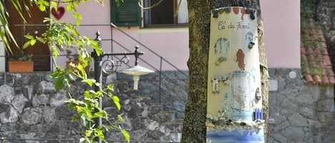 A tree with a sign that reads "Ca'du Ferra" attached to it.