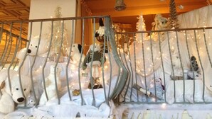A room with a metal railing, white teddy bears, and Christmas decorations. - Inter-hotel Au Pavillon Bleu (Ozoir-la-Ferriere)