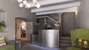 A modern reception area with a curved reception desk, a staircase, and seating areas. - The Originals Boutique, Hôtel Cassitel, Cassis Port (Cassis)