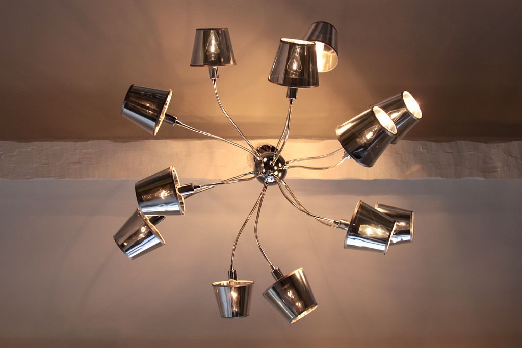 A ceiling with a central light fixture surrounded by eight cup-shaped lights.