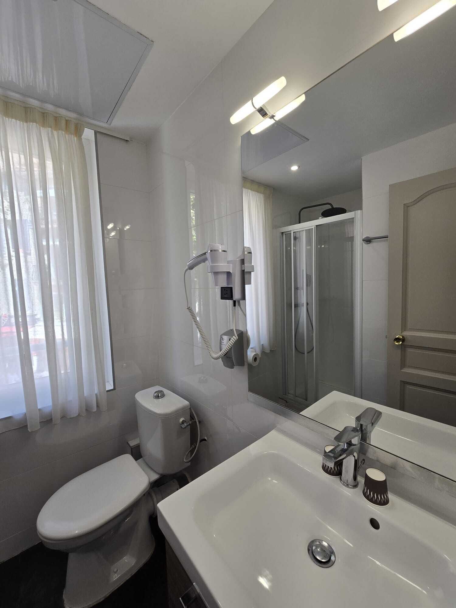 A modern bathroom with a toilet, sink, and shower.