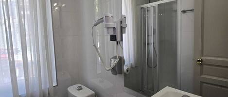 A modern bathroom with a toilet, sink, and shower.